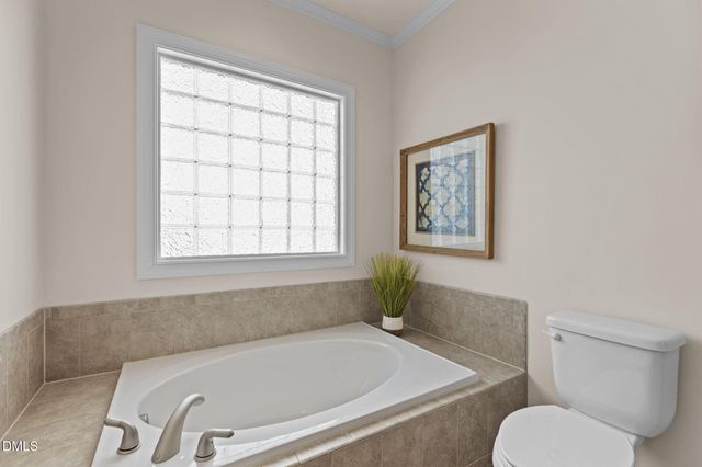 a bathroom with a granite countertop bathtub and a toilet