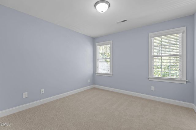 a view of an empty room with closet and a window