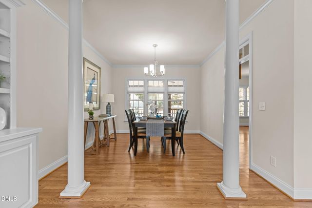 a dining room with furniture a chandelier and wooden floor