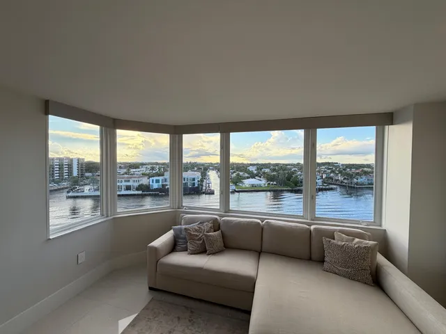 a living room with furniture and a large window with garden view