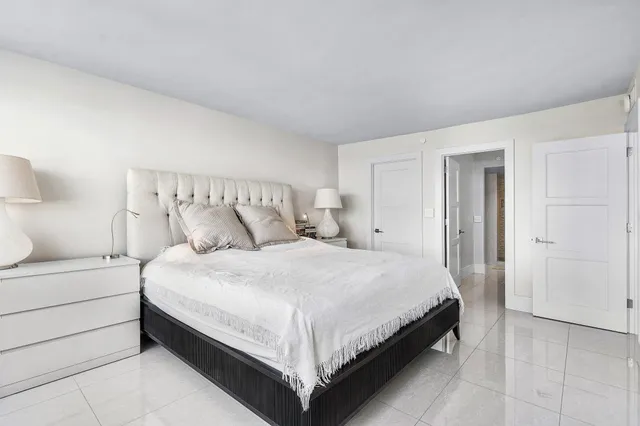 a large bed sitting in a bedroom and a lamp