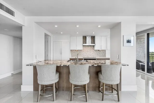 a kitchen with a dining table chairs cabinets and stainless steel appliances
