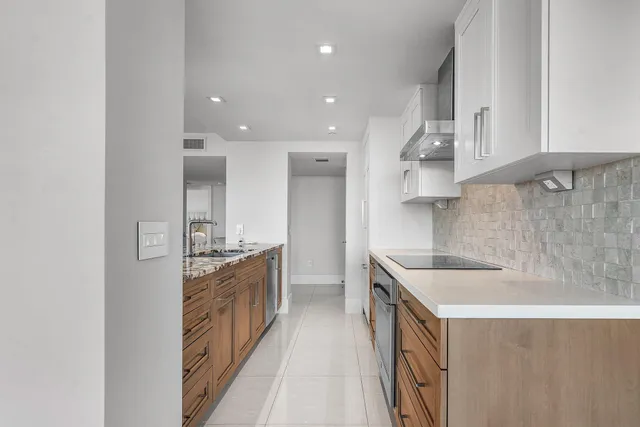 a kitchen with stainless steel appliances granite countertop a sink and a stove top oven