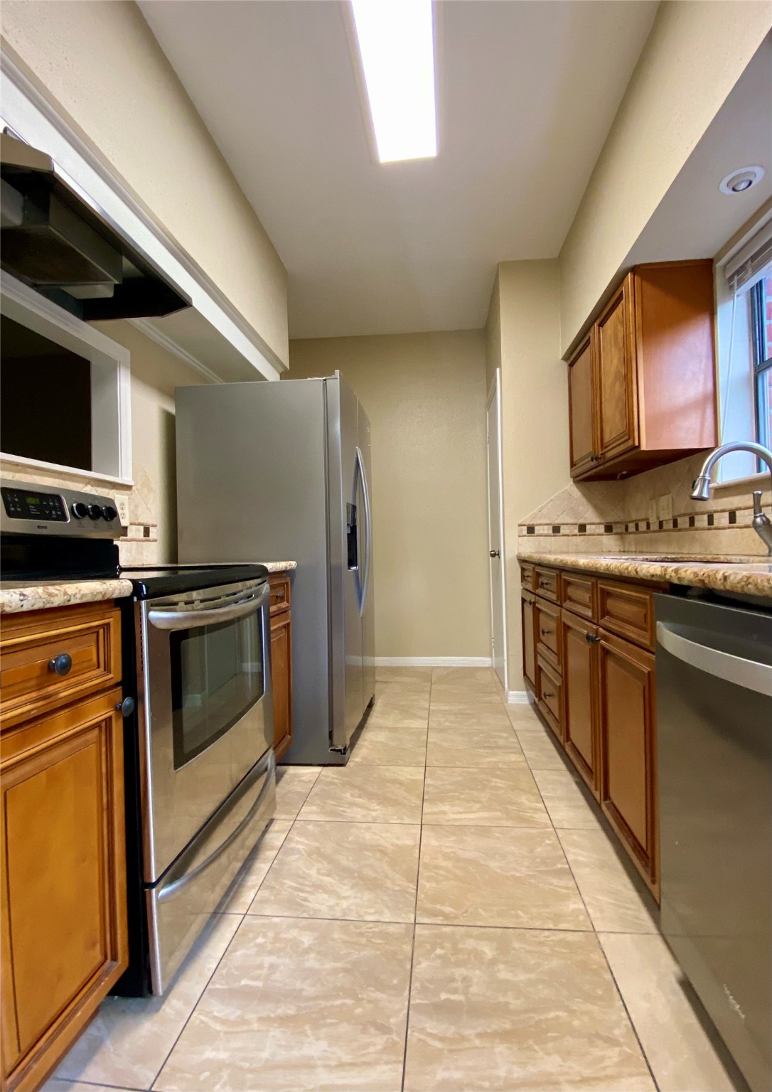 752 Augusta Drive Houston, TX 77057 - Photo 18 of 39 a kitchen with stainless steel appliances kitchen island granite countertop a stove top oven and sink