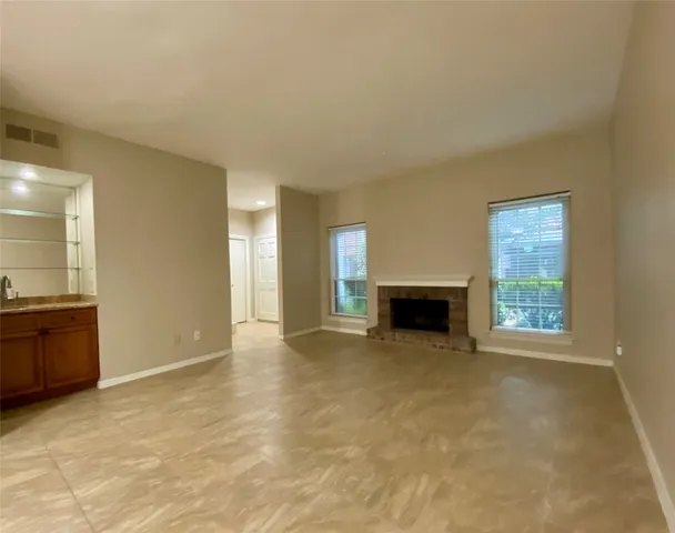 a view of an empty room with a fireplace and a window