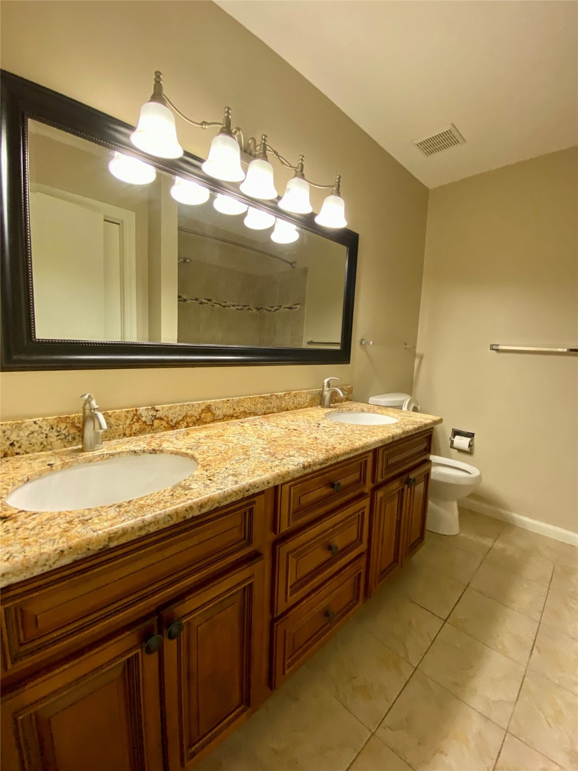 752 Augusta Drive Houston, TX 77057 - Photo 26 of 39 a bathroom with a granite countertop sink a large mirror and a bathtub