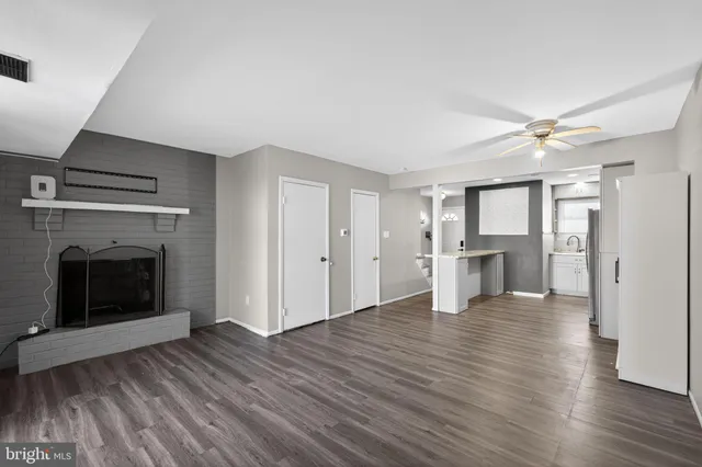 a view of a livingroom with wooden floor and a kitchen