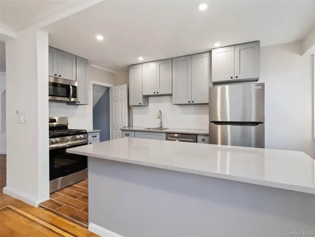 a kitchen with stainless steel appliances a refrigerator sink and microwave