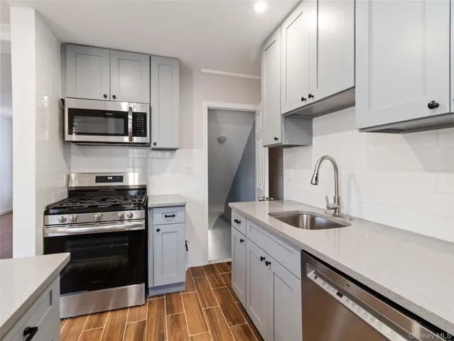 a kitchen with white cabinets and stainless steel appliances