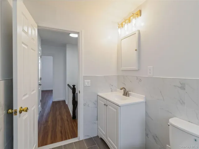 a bathroom with a sink and mirror with toilet