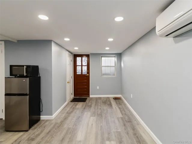 a view of hallway with a large window and wooden floor
