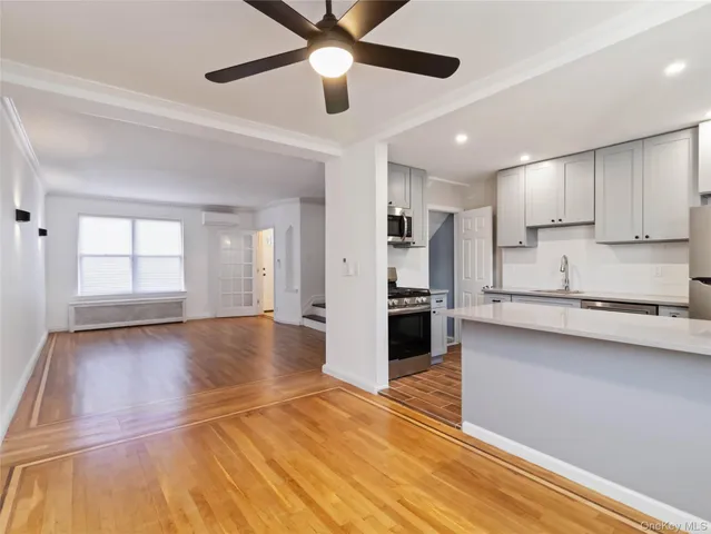 a view of a kitchen with wooden floor and a window