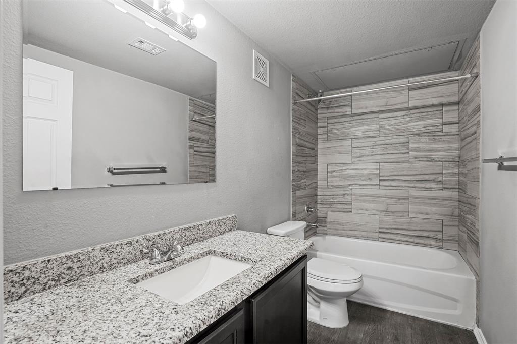 609 Meadow View Court, Unit 102 Denton, TX 76207 - Photo 12 of 13 a bathroom with a granite countertop sink toilet and shower