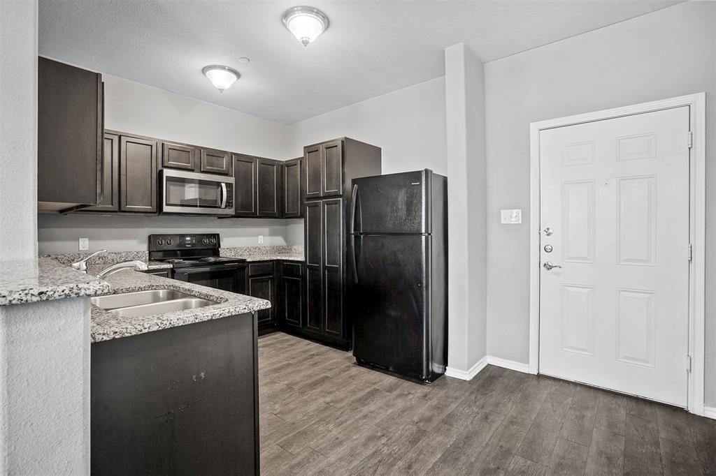 609 Meadow View Court, Unit 102 Denton, TX 76207 - Photo 3 of 13 a kitchen with stainless steel appliances granite countertop a refrigerator stove and sink