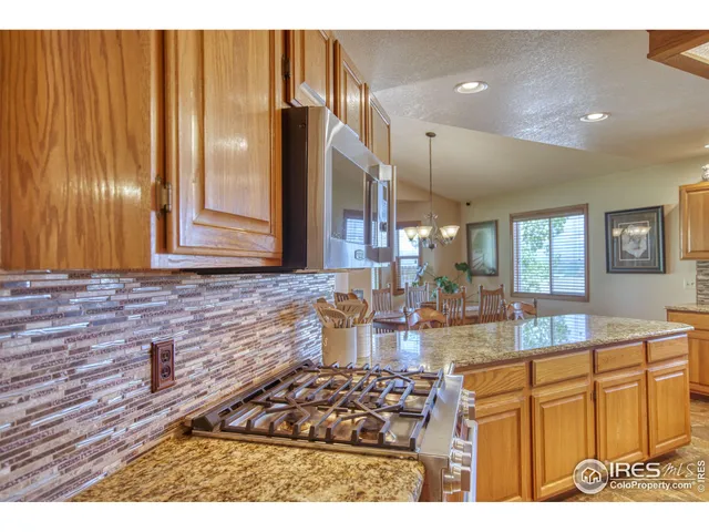a kitchen with stainless steel appliances granite countertop a stove a sink and a microwave oven with cabinets