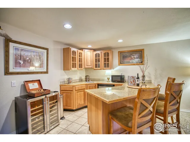 a open kitchen with stainless steel appliances kitchen island granite countertop a stove top oven a sink a dining table and chairs with wooden floor