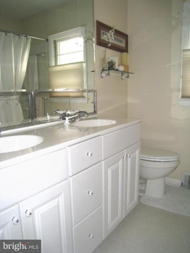 315 Hampton Road Linthicum Heights, MD 21090 - Photo 12 of 22 a bathroom with a granite countertop sink a toilet and a mirror
