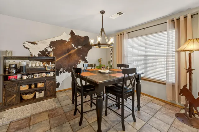 a view of a dining room and livingroom with furniture wooden floor and a chandelier