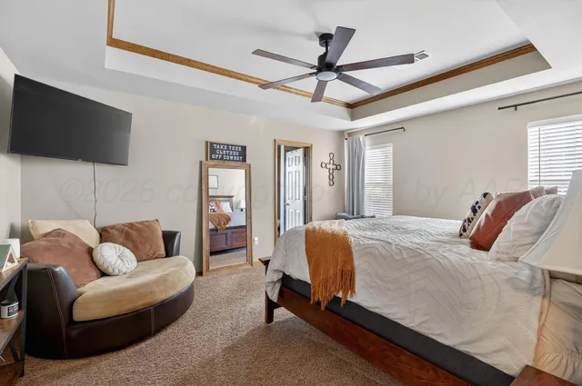 a bedroom with a bed a couch and a flat screen tv