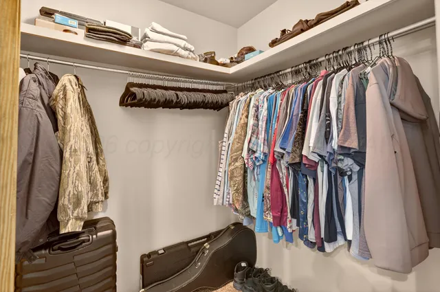 a view of walk in closet with clothes and shoes