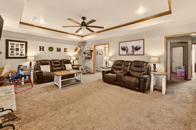 a living room with furniture and a ceiling fan
