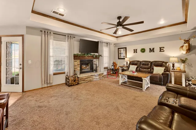 a view of a livingroom with furniture a flat screen tv and a ceiling fan