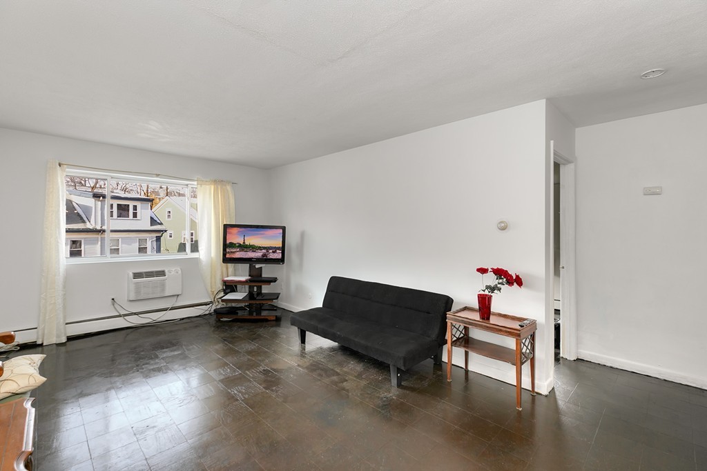 46 Adams Street, Unit C1 Boston, MA 02122 - Photo 2 of 13 a living room with furniture and a book shelf