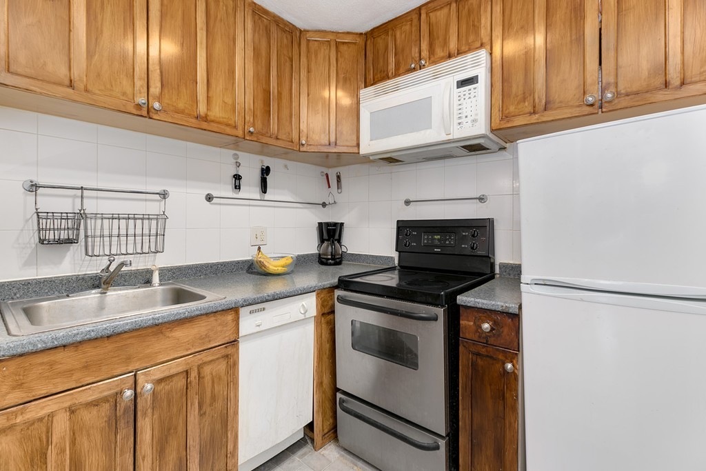46 Adams Street, Unit C1 Boston, MA 02122 - Photo 3 of 13 a kitchen with stainless steel appliances granite countertop a sink stove and cabinets