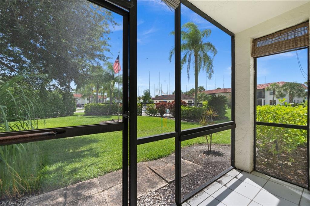 4251 27th Court Southwest, Unit 104 Naples, FL 34116 - Photo 22 of 22 a view of a porch with a floor to ceiling window next to a yard