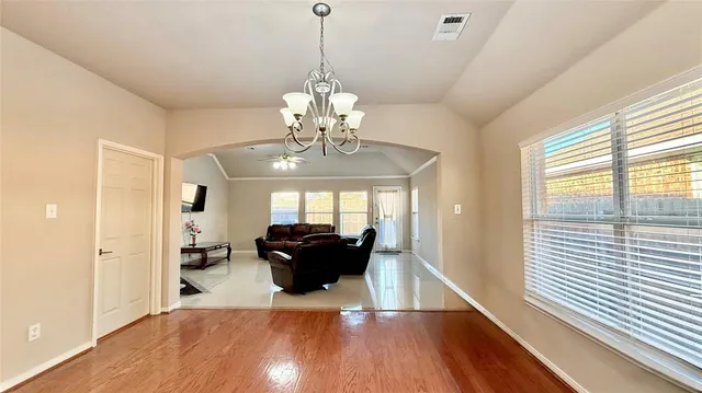 a view of a livingroom with furniture wooden floor and a chandelier