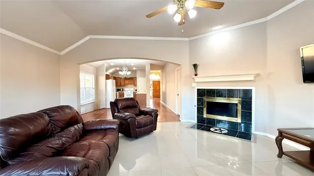 a living room with furniture a fireplace and a chandelier