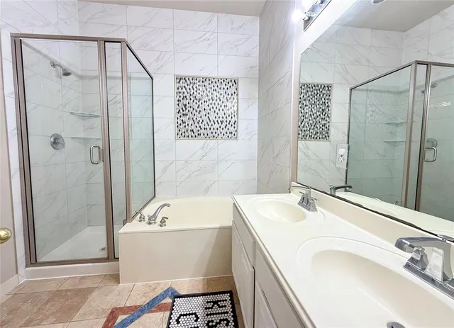 a bathroom with a tub a sink and a mirror