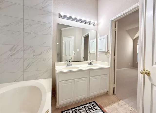 a spacious bathroom with a bathtub sink and mirror