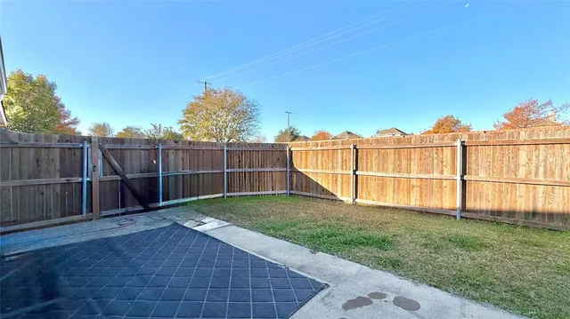 a view of a backyard with wooden fence