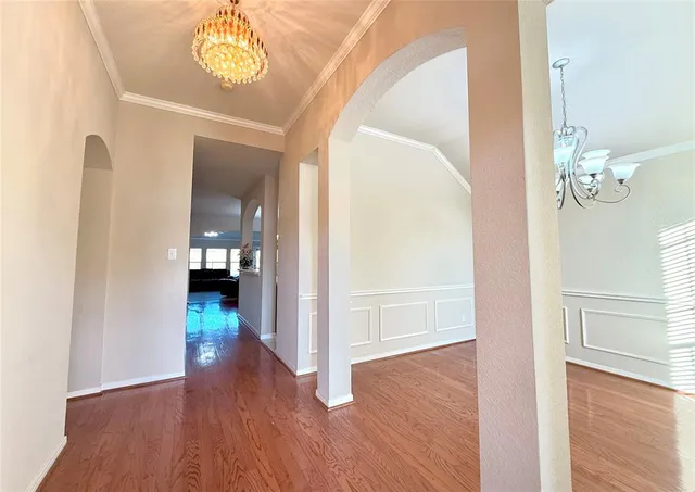 a view of a hallway with wooden floor and a living room