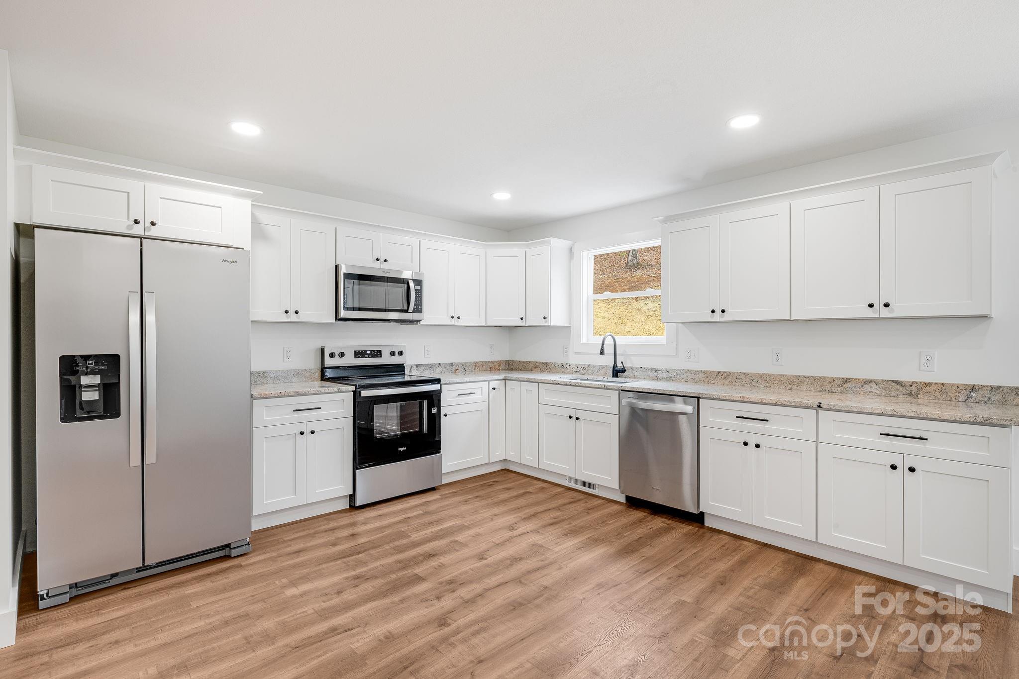 382 Holtzclaw Street Canton, NC 28716 - Photo 15 of 34 a kitchen with granite countertop white cabinets and stainless steel appliances