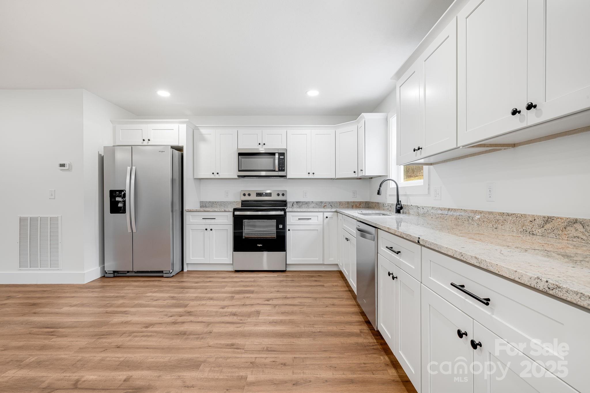 382 Holtzclaw Street Canton, NC 28716 - Photo 16 of 34 a kitchen with kitchen island granite countertop white cabinets stainless steel appliances and sink