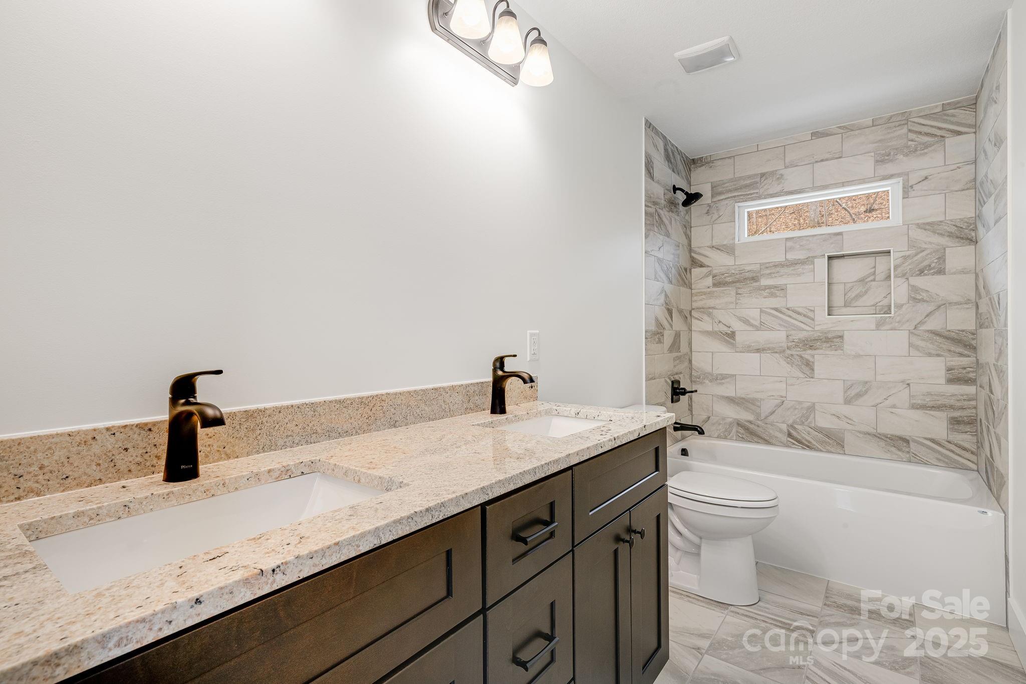 382 Holtzclaw Street Canton, NC 28716 - Photo 24 of 34 a bathroom with a granite countertop sink toilet a mirror and bathtub
