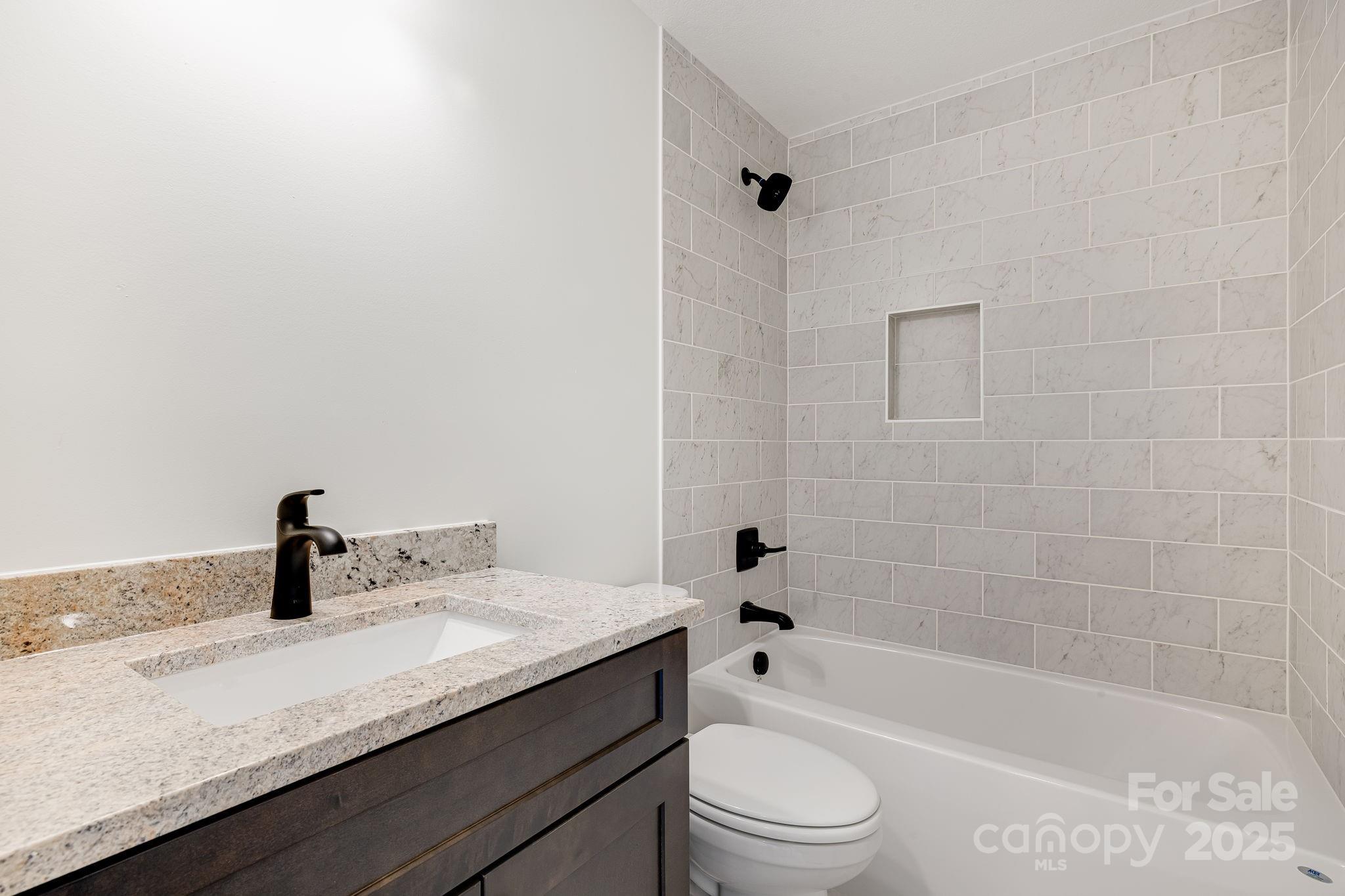382 Holtzclaw Street Canton, NC 28716 - Photo 29 of 34 a bathroom with a granite countertop sink a toilet and bathtub