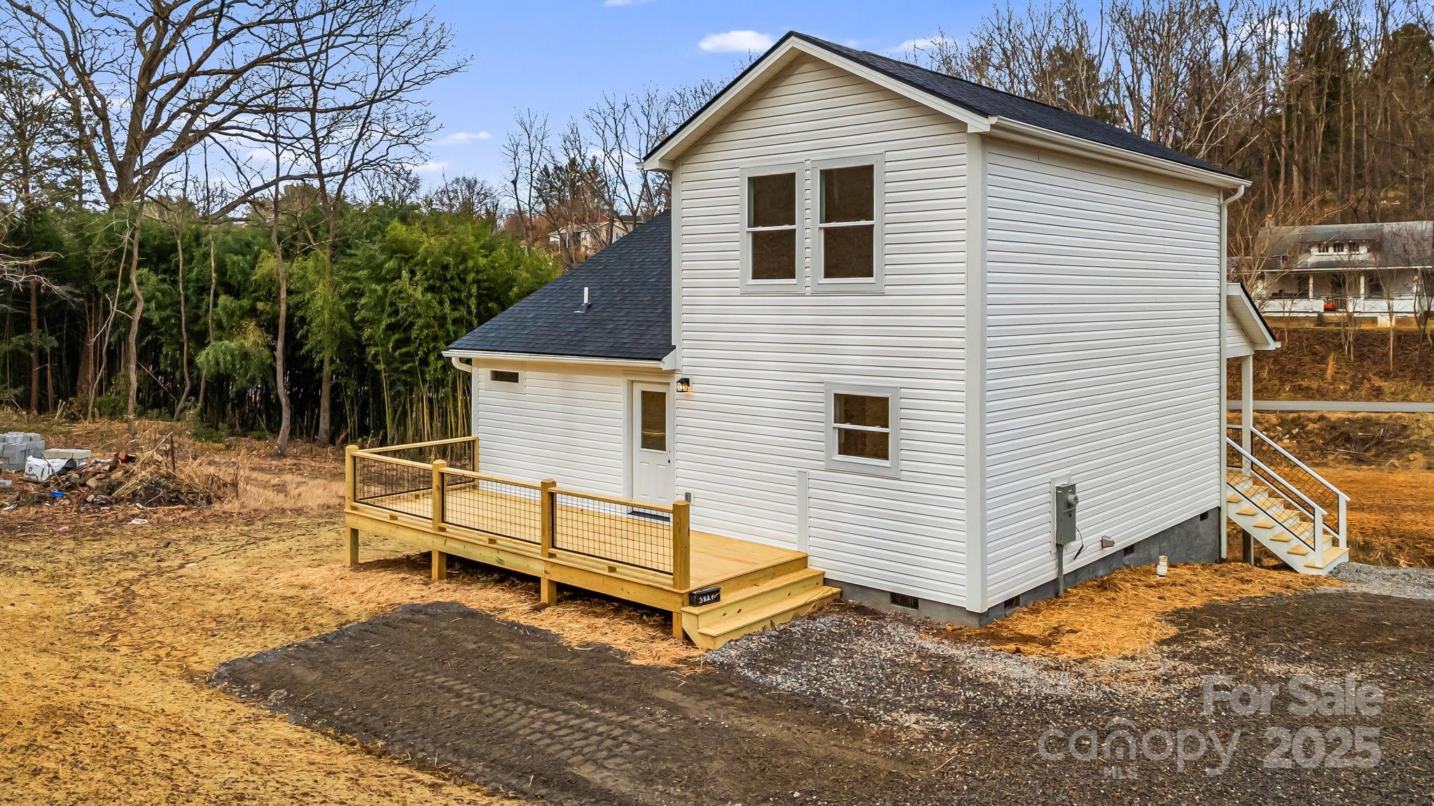 382 Holtzclaw Street Canton, NC 28716 - Photo 4 of 34 a view of a white house with a yard and wooden fence