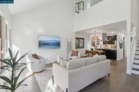 a living room with furniture and a view of kitchen