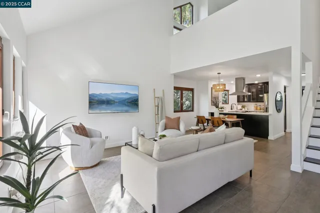 a living room with furniture and a view of kitchen