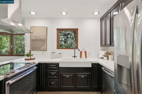a kitchen with a sink a stove and chairs with wooden floor