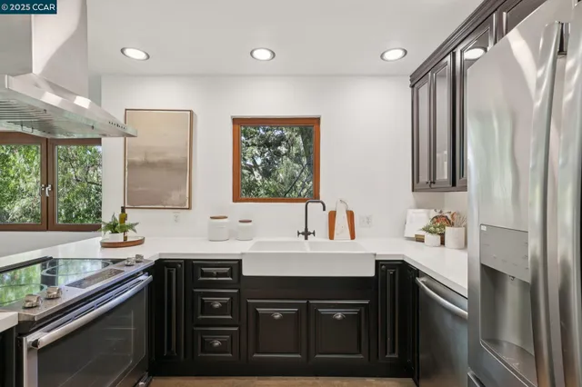 a kitchen with a sink a stove and chairs with wooden floor
