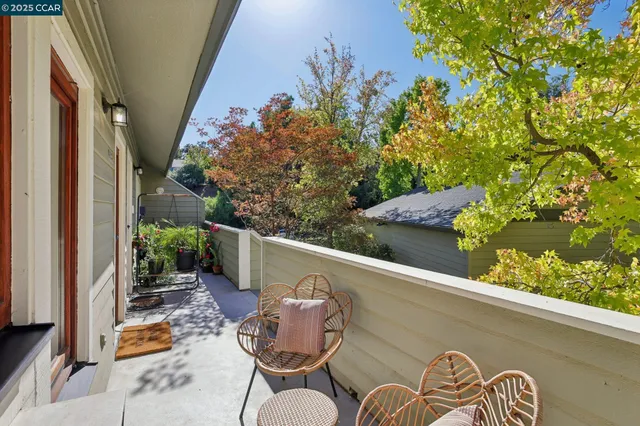 a backyard of a house with table and chairs potted plants
