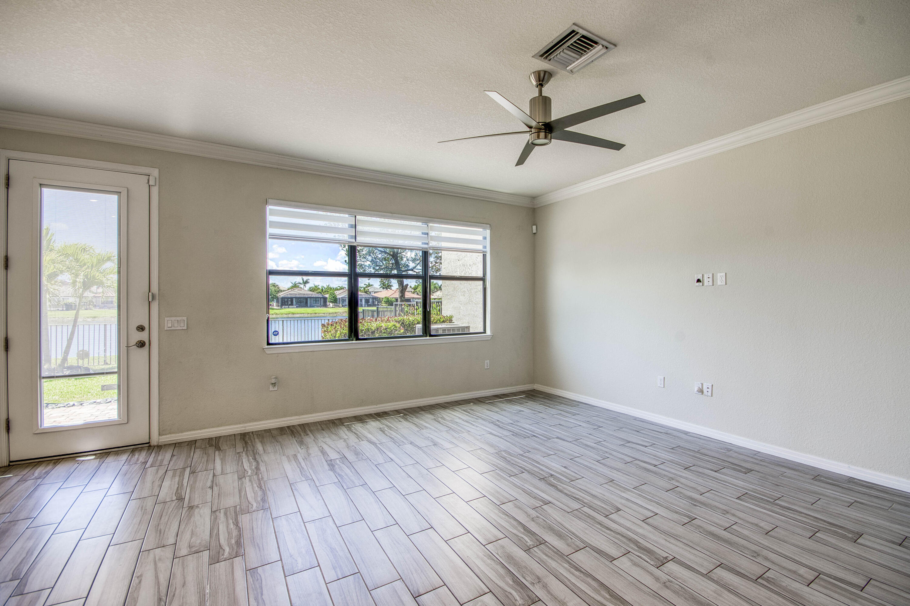8301 Rearing Lane Lake Worth, FL 33467 - Photo 10 of 33 a view of an empty room with wooden floor and a window