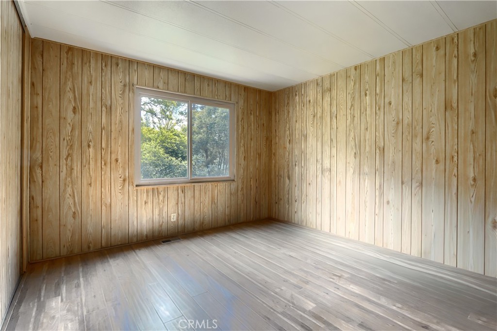 2843 East Westfall Road Mariposa, CA 95338 - Photo 24 of 47 an empty room with wooden floor and windows with curtains view