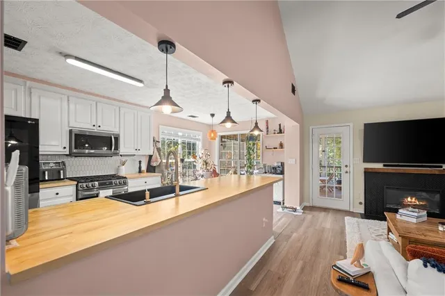 a large kitchen with cabinets a sink a window and stainless steel appliances