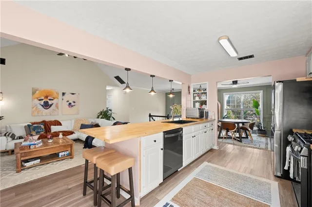 a large white kitchen with lots of counter top space and living room