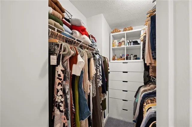 a view of walk in closet with clothes and shoes